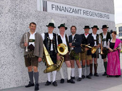  Die Blaskapelle steht vor dem Gebäude mit Aufschrift "Finanzamt Regensburg".